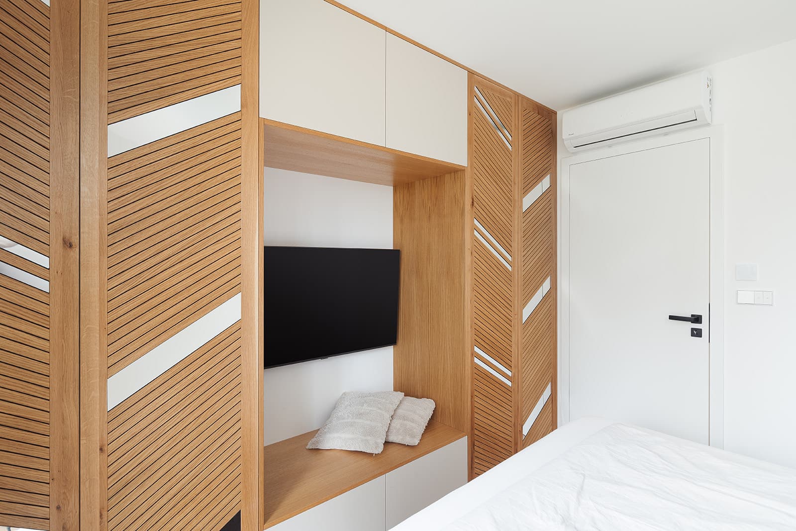 Bedroom with an oak slatted wall and a built-in walk-in closet, Kunice